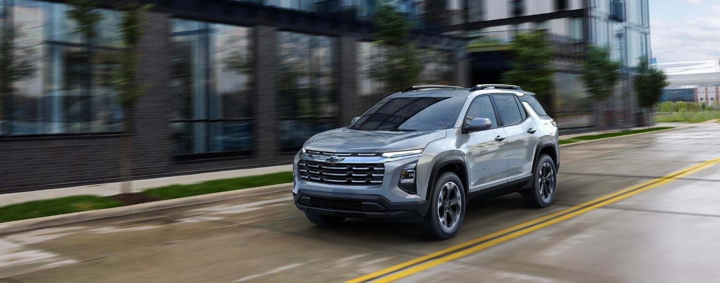 A silver 2025 Chevy Equinox LT driving on a city street.