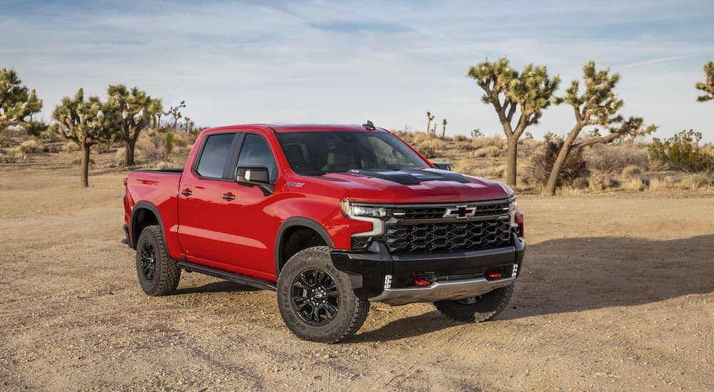 A red 2024 Chevy Silverado 1500 ZR2 is shown from the front at an angle after leaving a Chevy dealership.