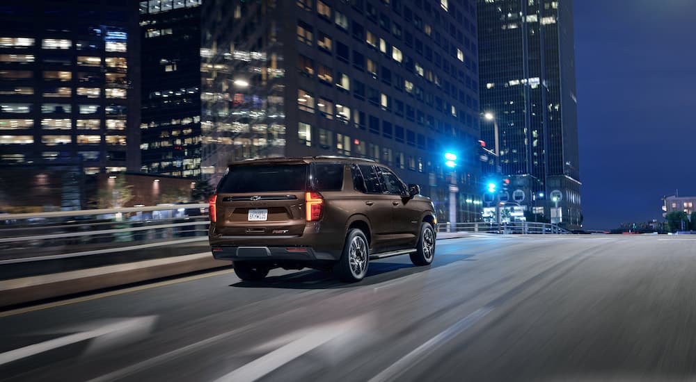 A brown 2024 Chevy Tahoe RST is shown from the rear at an angle after leaving a Chevy dealership.