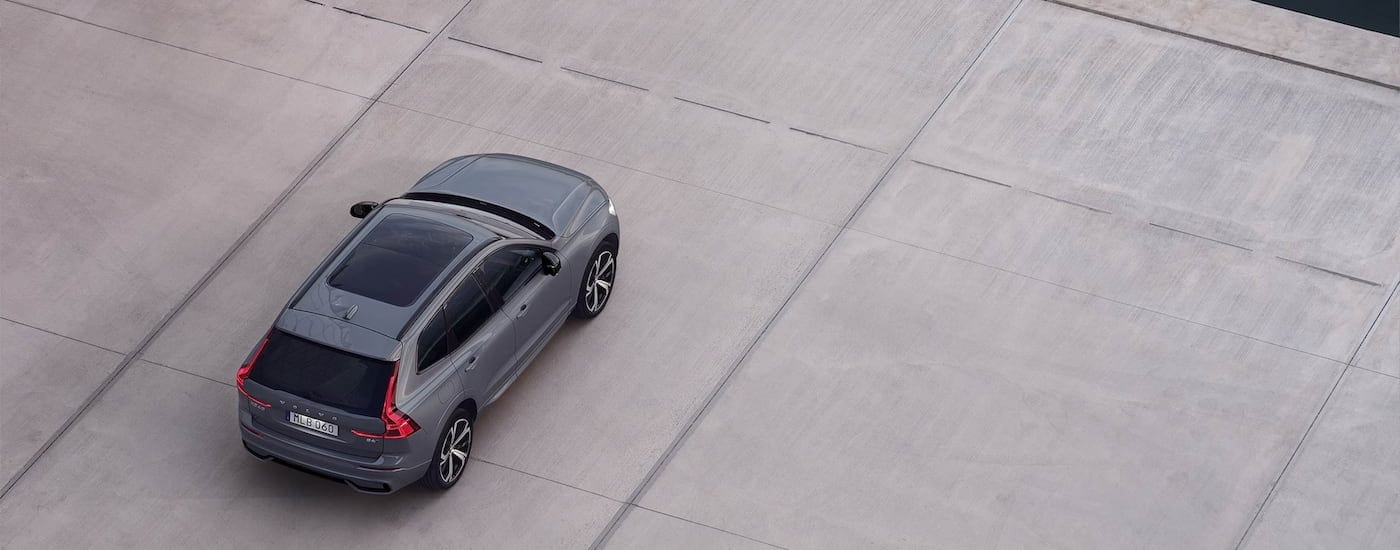 A grey 2024 Volvo XC60 is shown from a high angle parked on a concrete slab after leaving a Volvo dealership near Pittsfield.