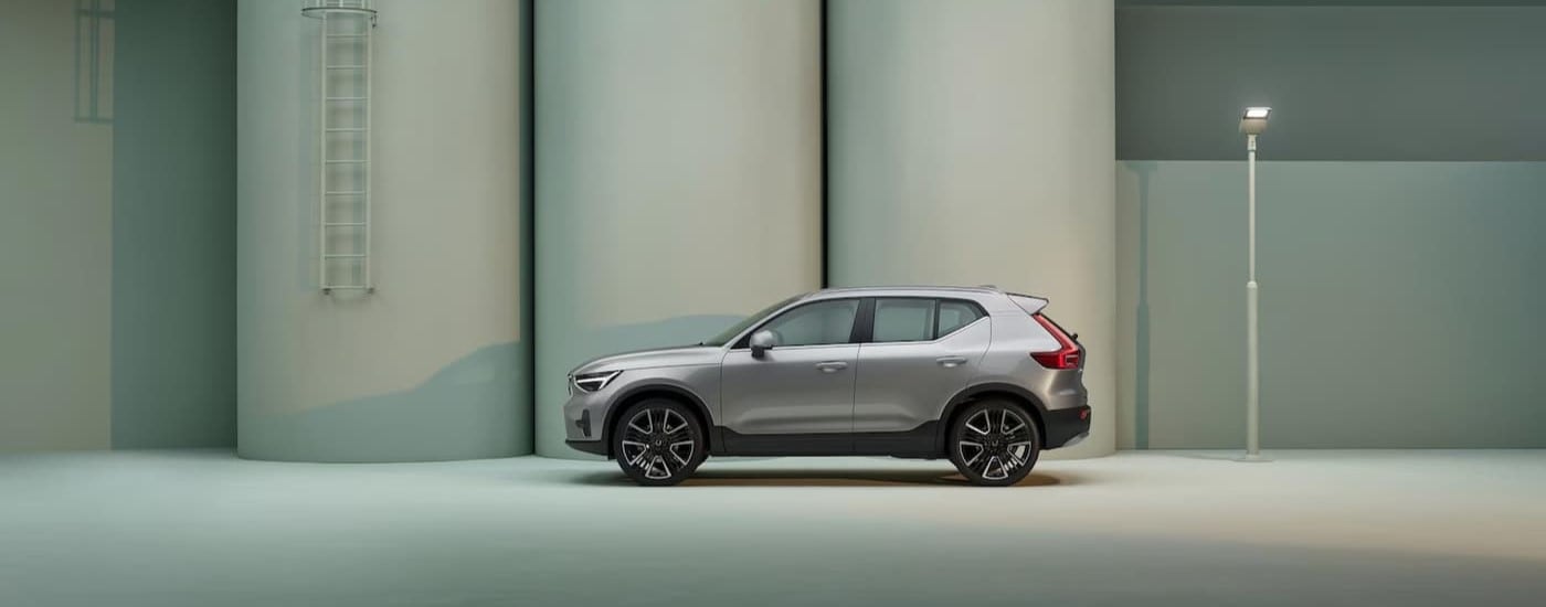 A silver 2025 Volvo XC40 is shown parked near a ladder.