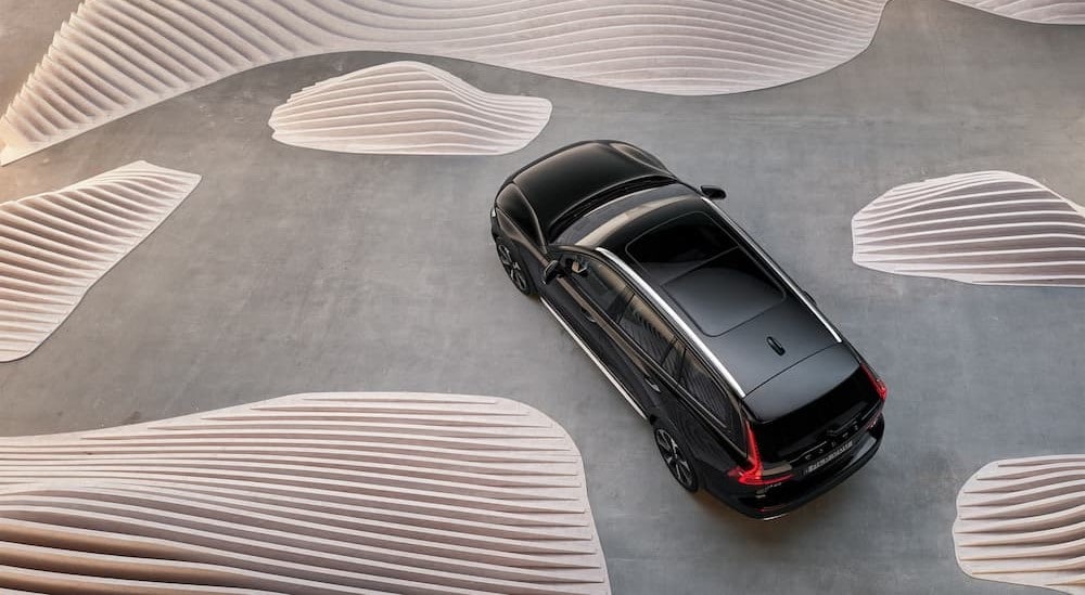 An aerial view is shown of a black 2025 Volvo V60 Cross Country.