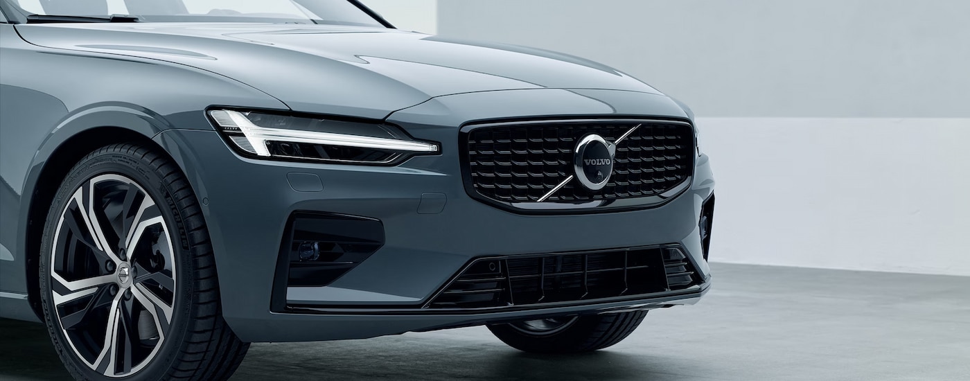 Close-up of the front end of a grey 2024 Volvo S60 at a Volvo dealership near Stockbridge.