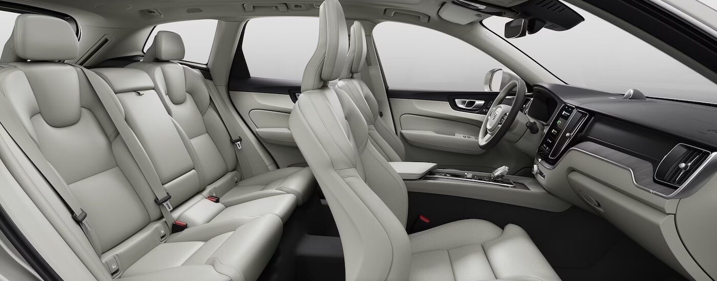 The white interior of a 2024 Volvo XC60 is shown from the passenger side.