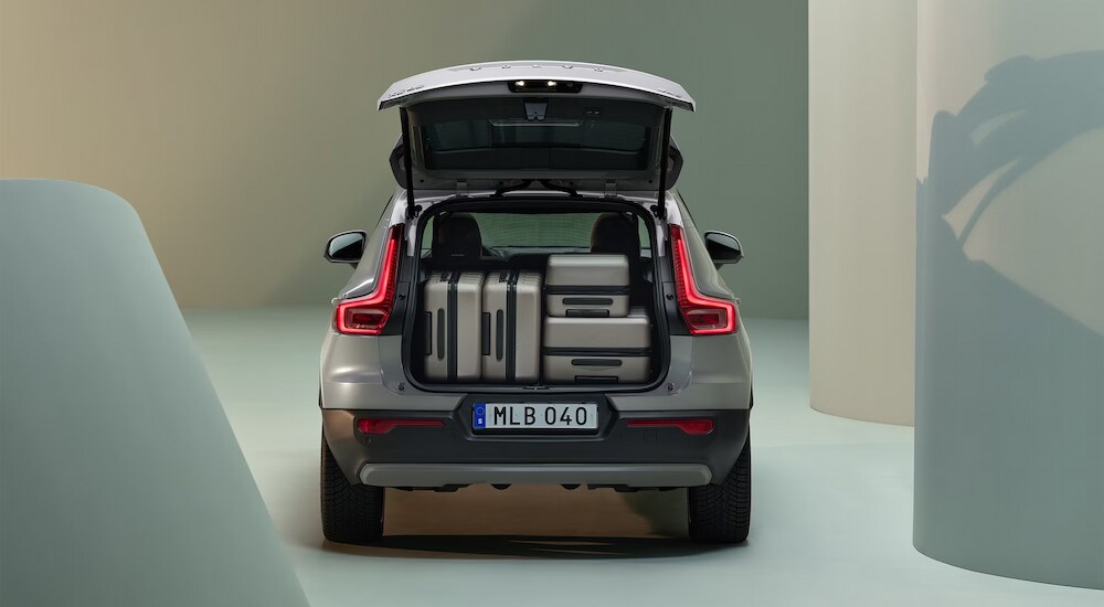 The open trunk of a 2024 Volvo XC40 with luggage stacked inside.