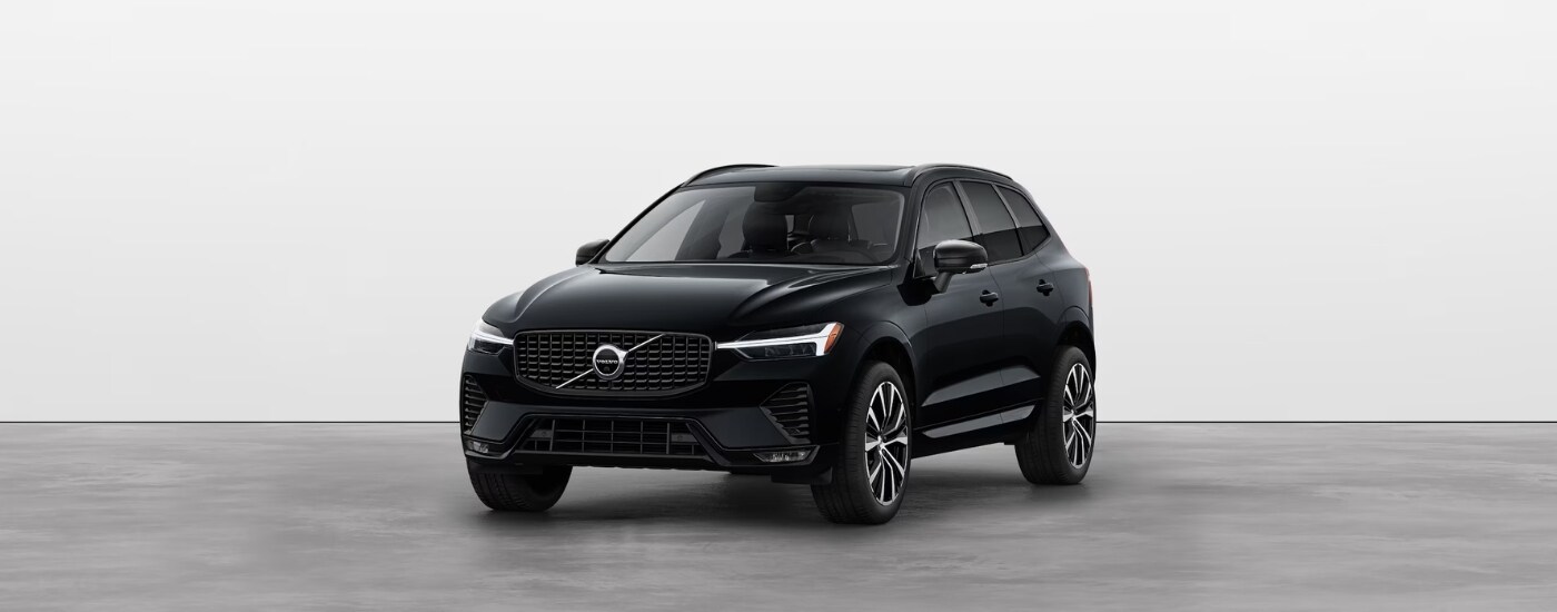 A black 2025 Volvo XC60 for sale near Pittsfield parked in a dealer showroom.