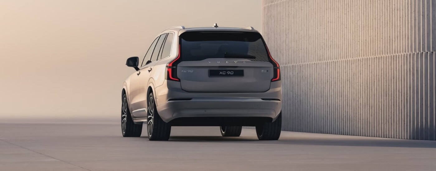 A tan 2025 Volvo XC90 is shown from the rear at an angle.