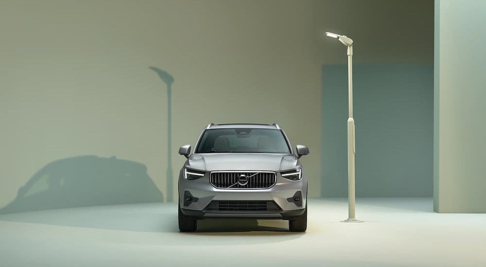 A silver 2025 Volvo XC40 is shown parked near a lamp post.
