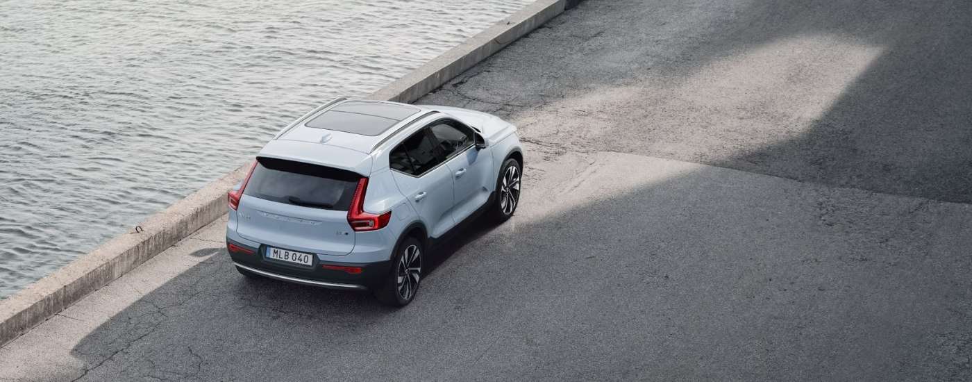 A white 2025 Volvo XC40 is parked near a river.