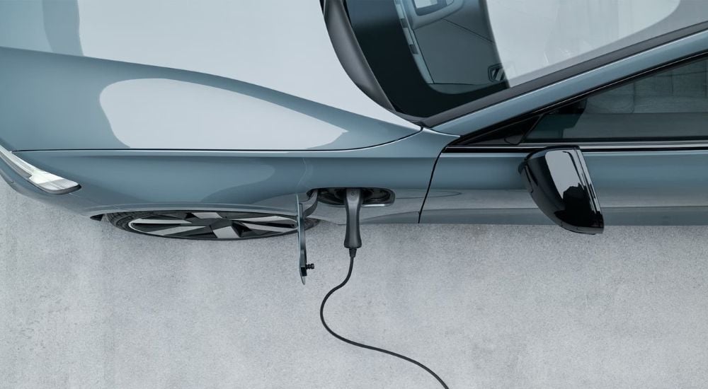 A blue 2024 Volvo S60 Recharge is shown from a high angle charging.