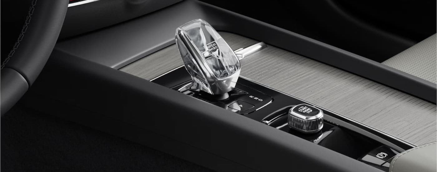 A close-up of the center console shifter is shown in a 2025 Volvo V60 Cross Country.