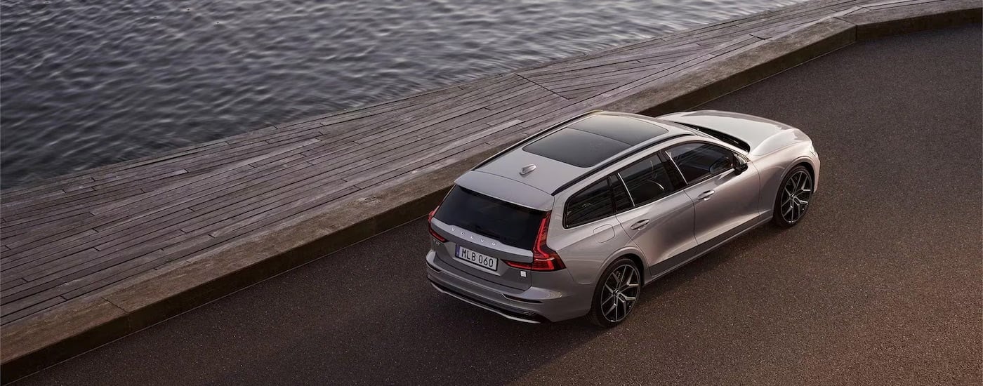 A silver 2024 Volvo V60 T8 Recharge is shown from the rear at a high angle after leaving a Volvo dealer near Lenox.