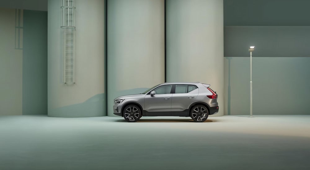 A silver 2025 Volvo XC40 is shown parked near a Volvo dealer near Stockbridge.