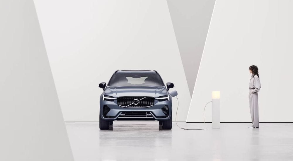 A blue 2024 Volvo XC60 Recharge is shown charging.