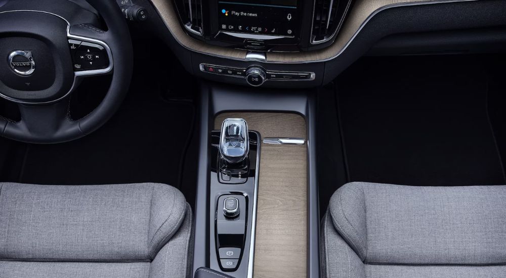 The black and wood-grain center console is shown in a 2024 Volvo XC60 Recharge.