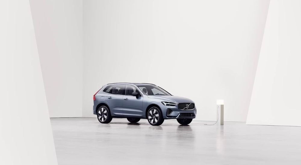 A blue 2024 Volvo XC60 Recharge is shown charging after leaving Volvo dealership.
