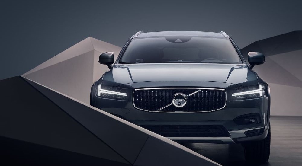 Front view of a grey 2023 Volvo V90 Cross Country parked in a showroom.
