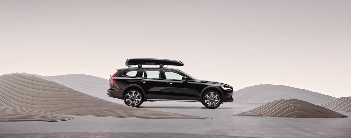 A black 2025 Volvo V60 Cross Country for sale is shown parked near art.