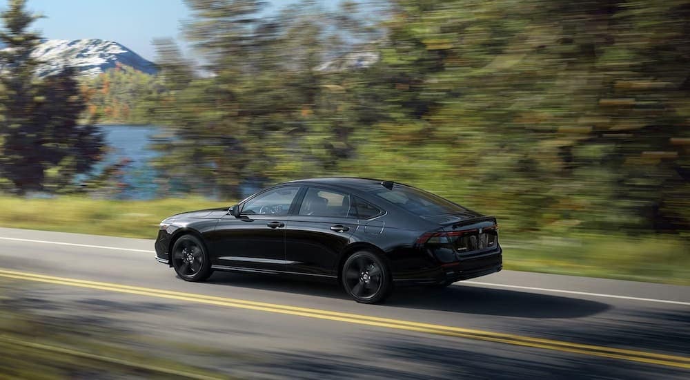 A black 2024 Honda Accord is shown from the side while driving.