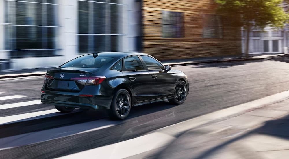 Honda%20Civic%20for%20sale%20-%202025%20Honda%20Civic%20Sport%20-%20Rear.jpg A black 2025 Honda Civic Sport is shown driving on a city street.