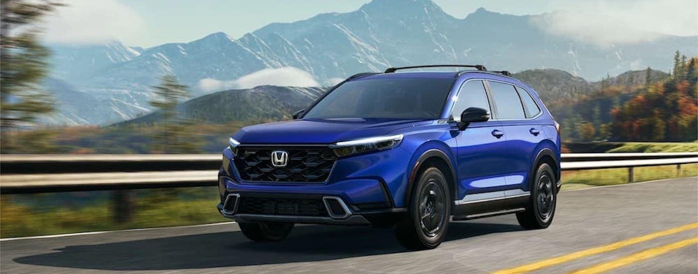 A blue 2024 Honda CR-V Hybrid is shown from the front at an angle.