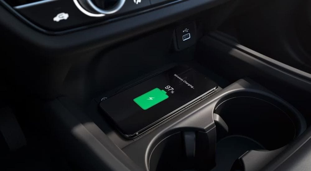 A close-up shows a phone charging in a 2025 Honda HR-V EX-L.