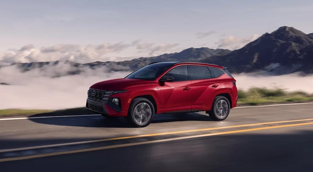Honda%20CR-V%20Hybrid%20for%20sale%20-%202025%20Hyundai%20Tucson%20Hybrid%20-%20Driving.jpg A red 2025 Hyundai Tucson Hybrid is shown driving on a highway.