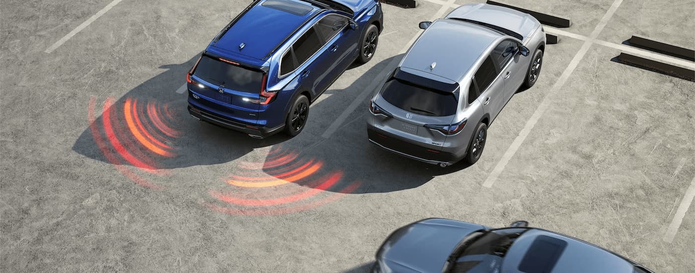 A blue 2023 Honda CR-V is reversing out of a parking lot space.