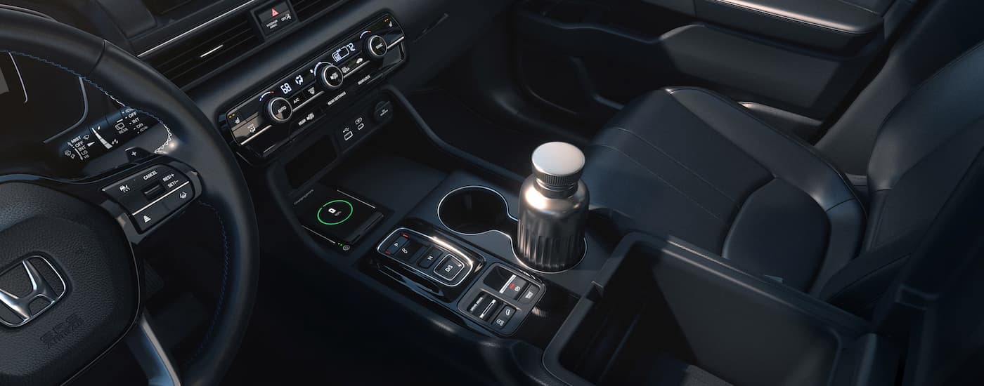 A silver water bottle is in the center console of a 2025 Honda Pilot for sale.