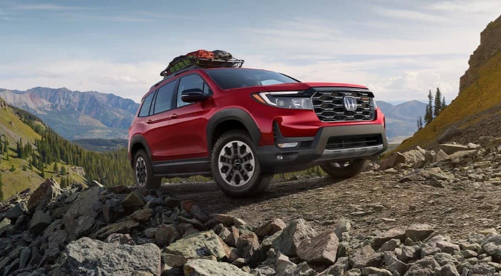 Honda dealership near Pittsfield - 2024 Honda Passport Trailsport - Red.jpg A red 2024 Honda Passport TrailSport is shown driving off-road.