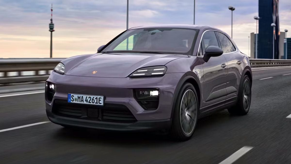 Porsche Macan Electric driving down a road