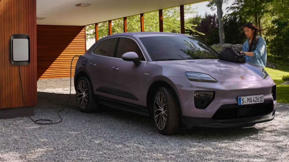 Porsche Macan Electric charging outside a modern house