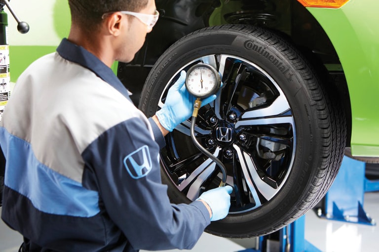 A technician checking tire pressure