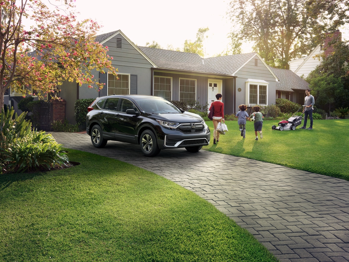 dark gray Honda CR-V parked in front of a suburban garage