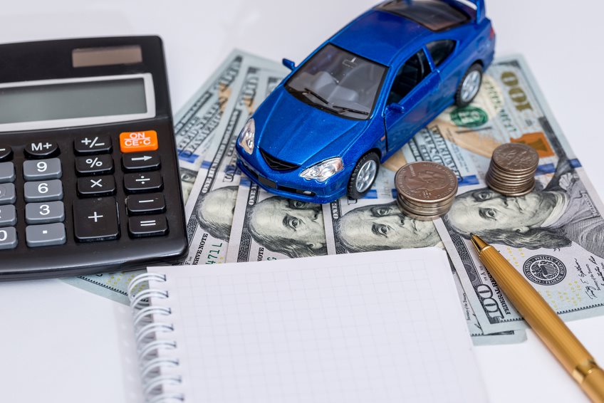 Financing image with cash, a calculator, a notepad, and a toy car