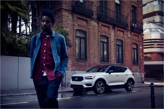 Man walking with Volvo XC40 by brick building in background.jpg