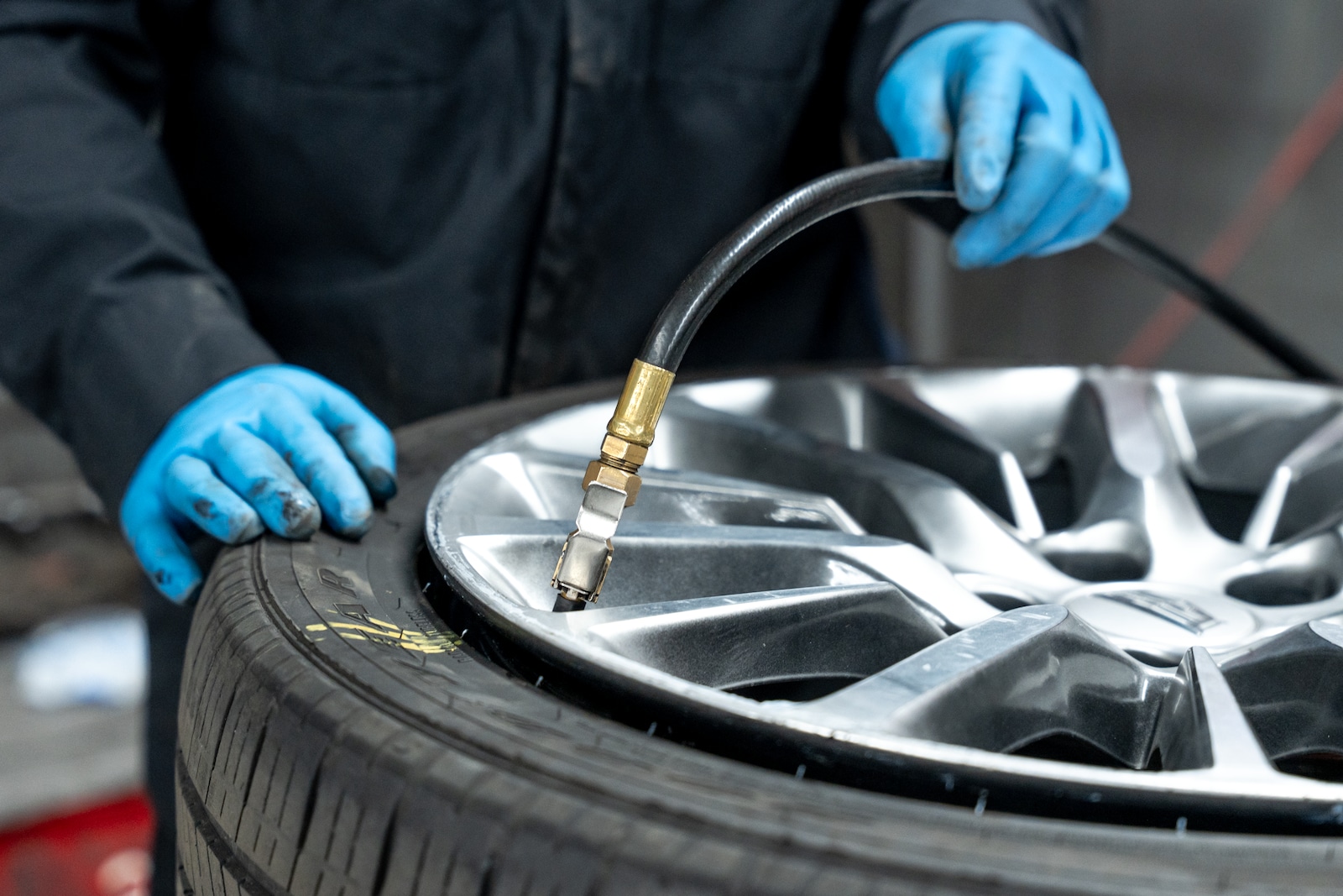 Technician inspecting tire tread wear