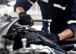 Mechanic using wrench, working on car engine