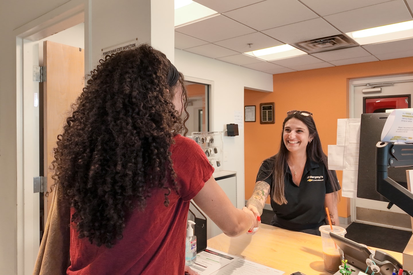 Service advisor greeting a customer in the Bergey's Chevrolet of Plymouth Meeting service drive