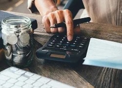 Person at desk pressing buttons on calculator