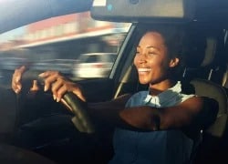 Woman smiling while driving car
