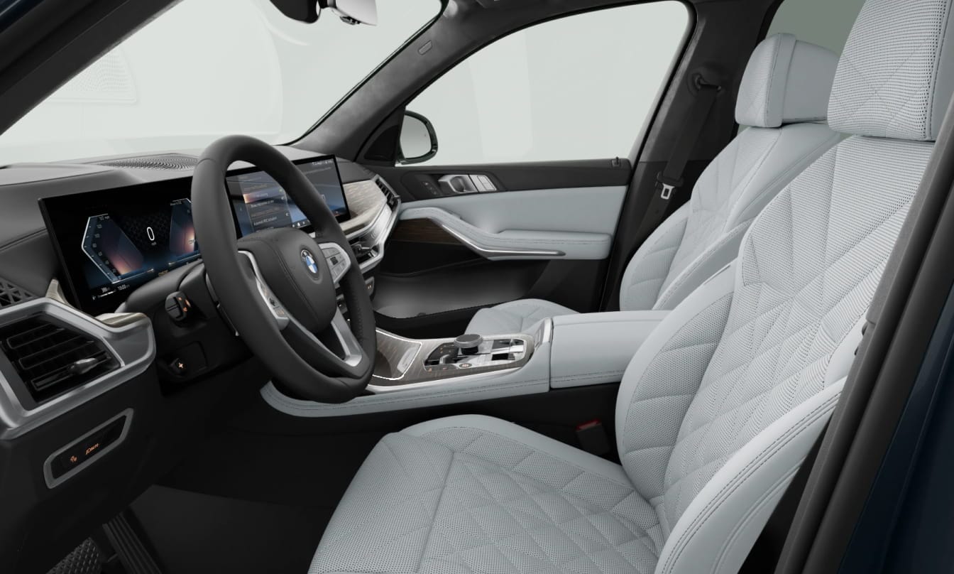 BMW X7 interior featuring white quilted leather seats, a digital dashboard, and elegant wood trim accents.