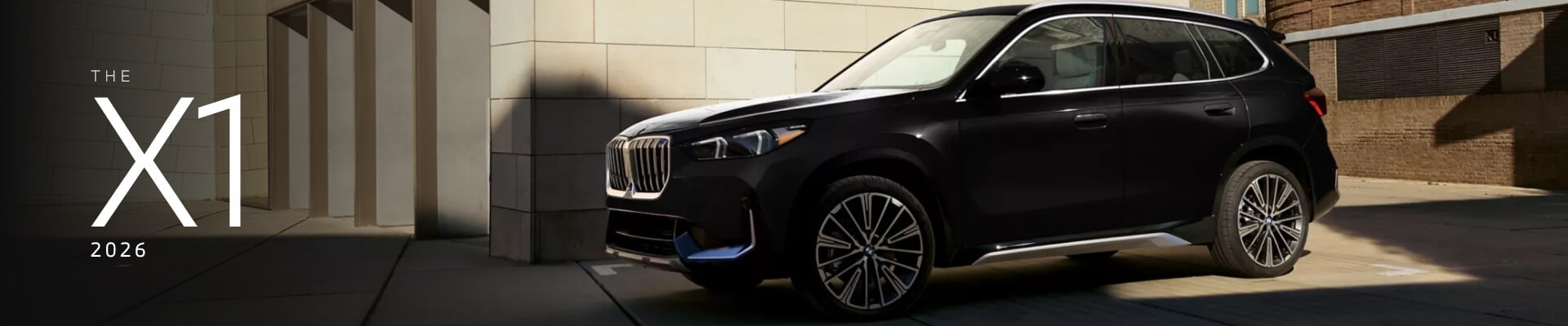 2026 BMW X1 in Black Sapphire parked in front of a stone building