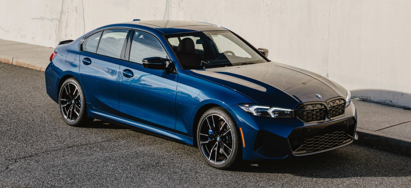 A new BMW M340i xDrive 50 Jahre Edition in blue parked along a sidewalk