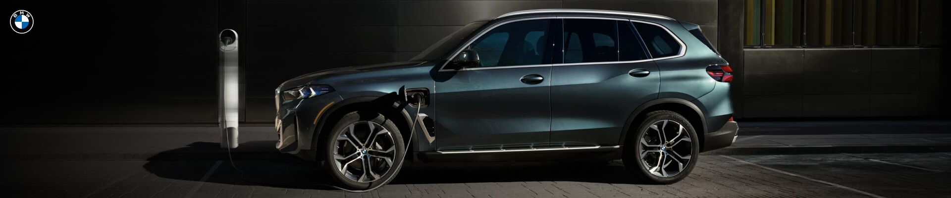 BMW X5 in Blue Ridge Mountain Metallic charging in a parking spot