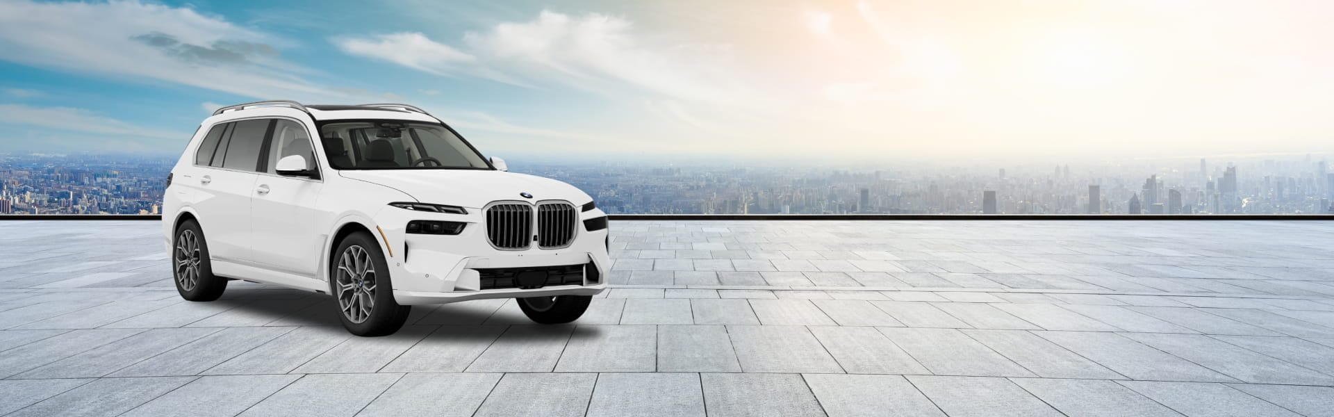 White BMW X7 SUV displayed on a spacious tiled terrace with a panoramic city skyline in the background.