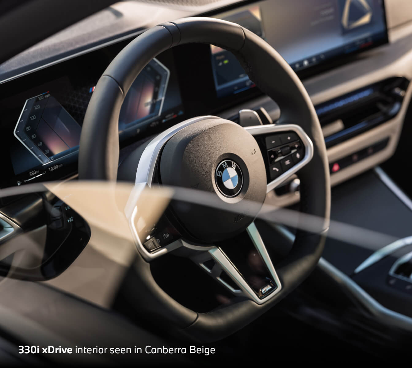 2026 BMW 330i xDrive with Canberra Beige interior, close-up of steering wheel and curved digital display.