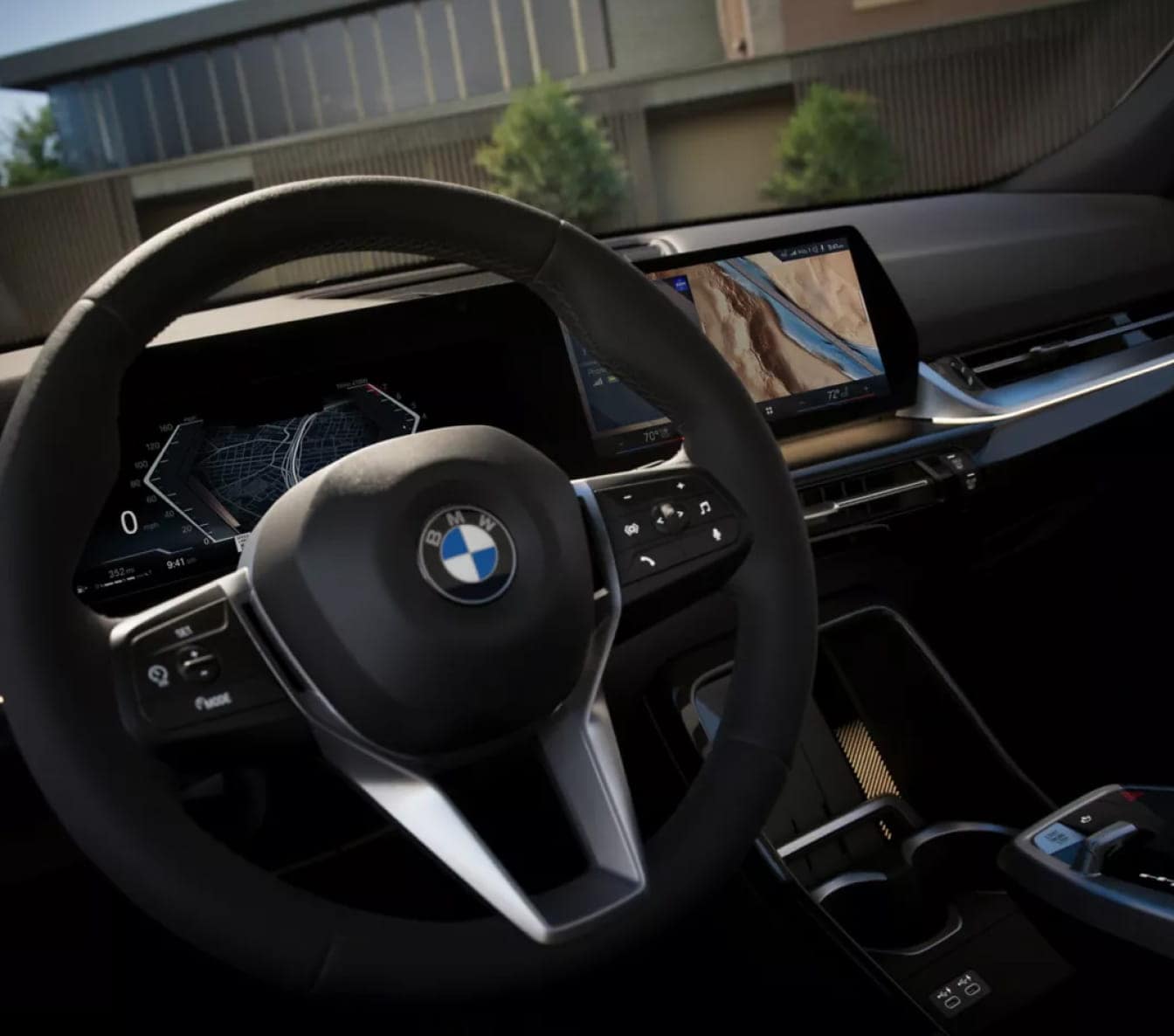 A driver’s view of the BMW X2 cockpit featuring a multifunction steering wheel and dual digital displays with navigation.