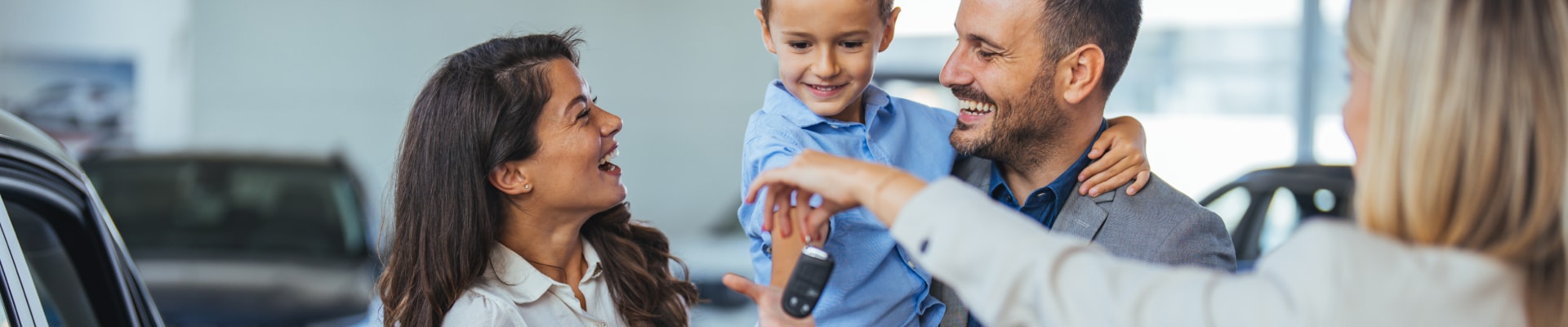 BMW Saleswoman handing new keys over to a family of 3