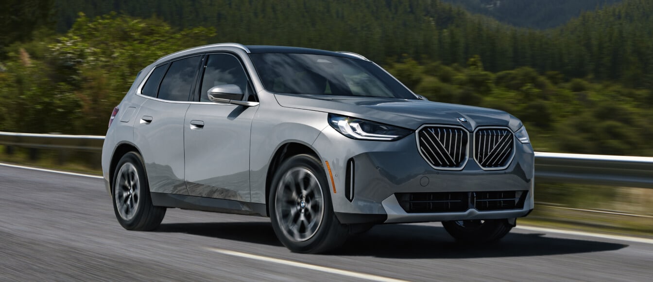 Front three-quarter view of a new 2025 BMW X3 driving on the highway